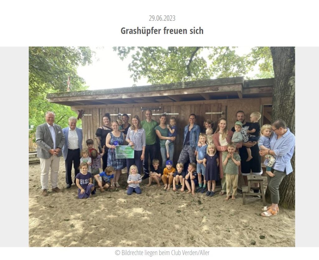 Eltern und Kinder der Kita Grashüpfer vor dem neuen Gründach